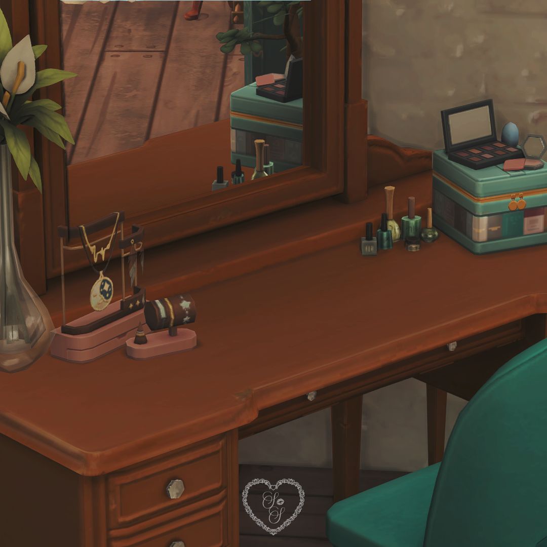 Close-up of emerald vanity with makeup, jewelry, and cozy wood details