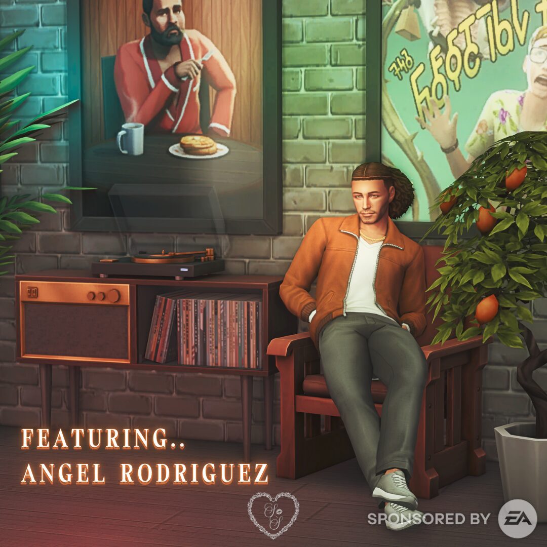 Angel Rodriguez reclines in a wood-framed chair, rocking an orange zip-up jacket over a white tee and grey pants—laid-back and cozy.