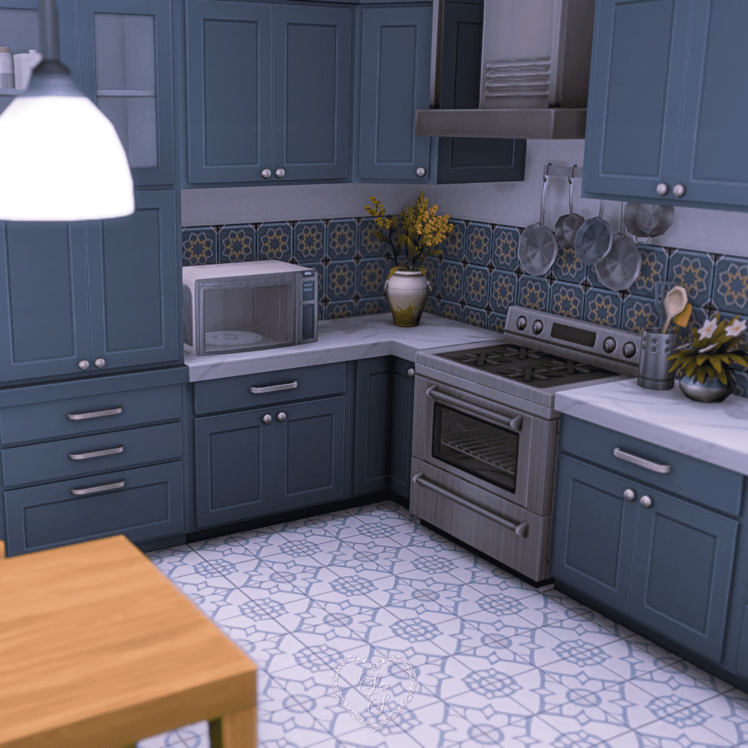 A stylish kitchen in the apartment, with blue cabinets, floral tile backsplash, and cozy decor including a vase of yellow flowers.