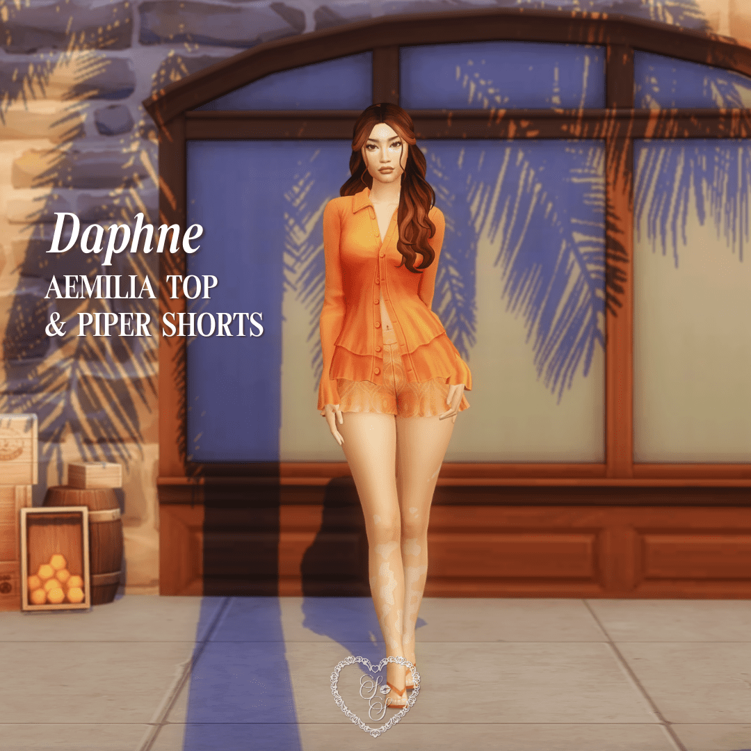 Daphne wears the Aemilia Top and Piper Shorts in a vivid orange, framed by a Mediterranean market backdrop.