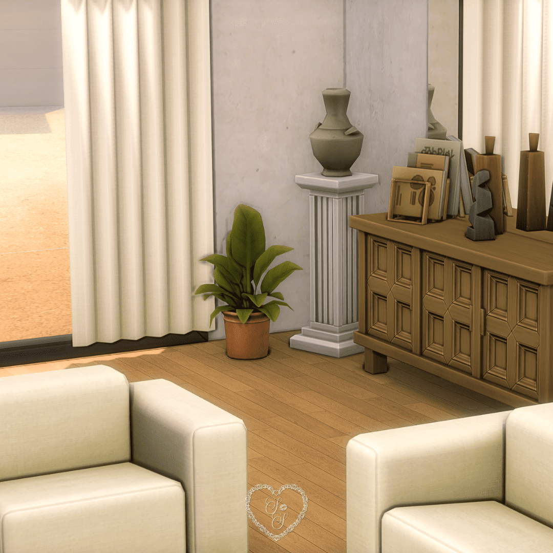 A chic interior corner featuring a pedestal vase, indoor plants, and a wood console table decorated with sculptural accents and books.