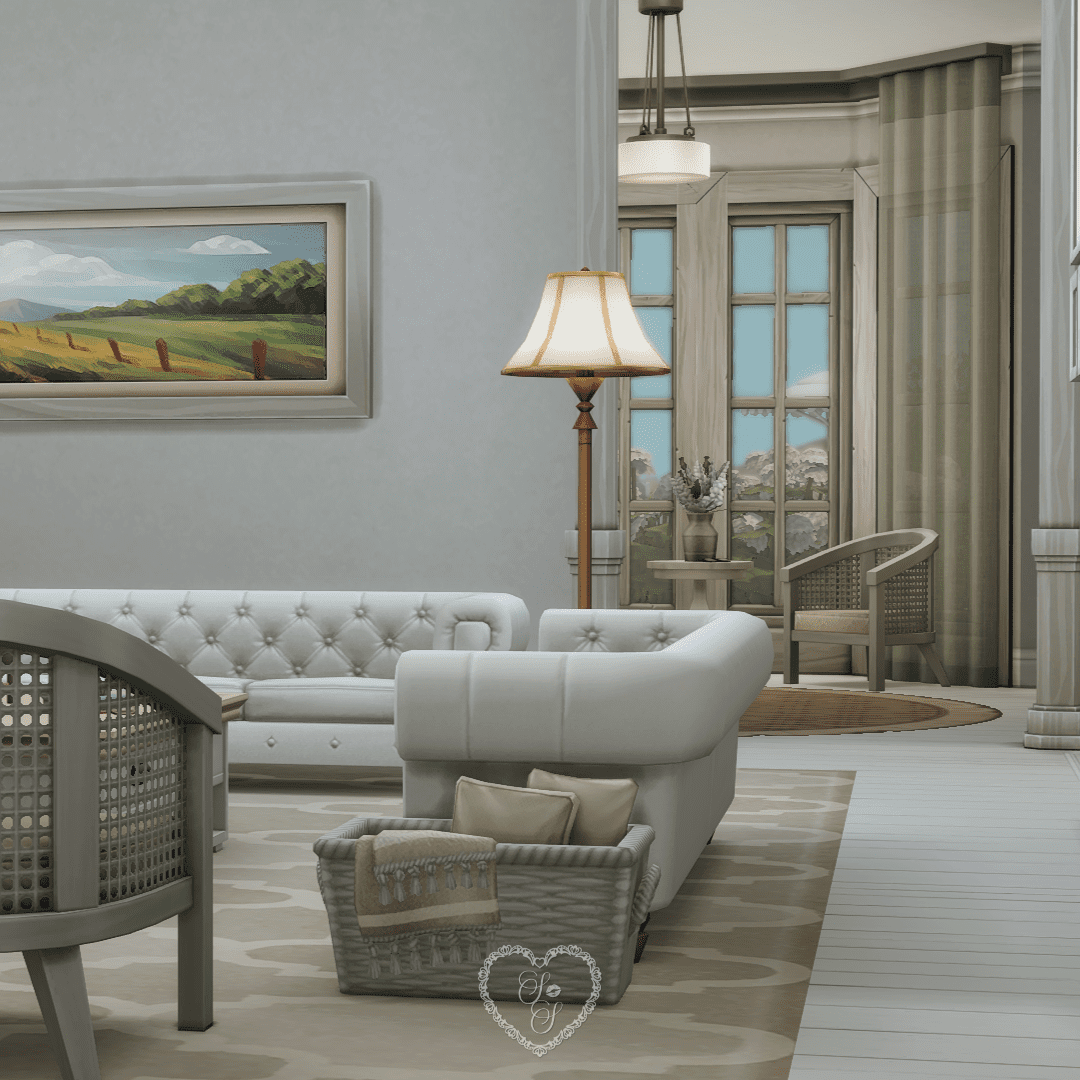 Elegant sitting room with white sofas, a cozy corner chair, fireplace, and views of the lush pink hydrangeas outside.