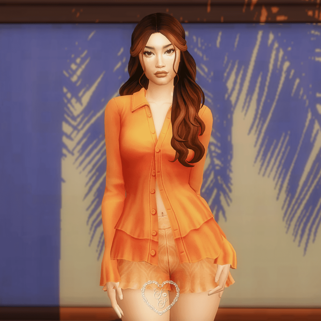 Daphne wears the Aemilia Top and Piper Shorts in a vivid orange, framed by a Mediterranean market backdrop.