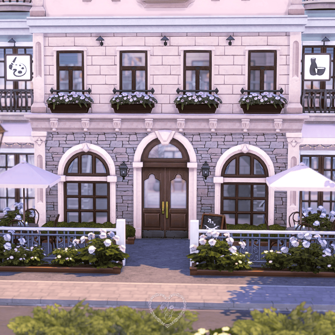 Close-up of the café’s arched double front doors with tall windows, hanging lanterns, and flower-lined railings.