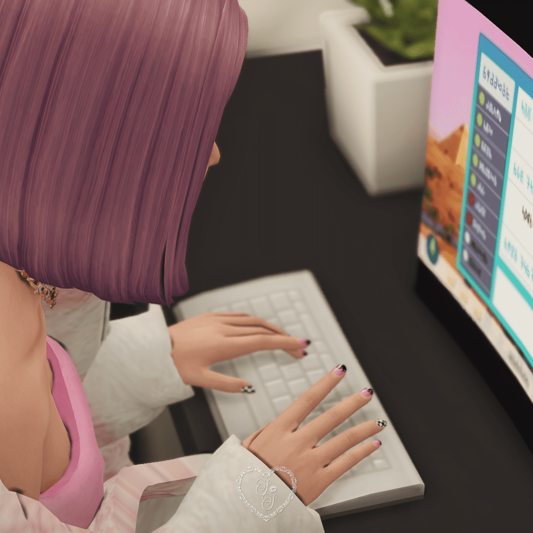 Close-up of Anaya Mori’s hands on a keyboard, showing off her black and pink manicure while playing The Sims 4 on a PC.