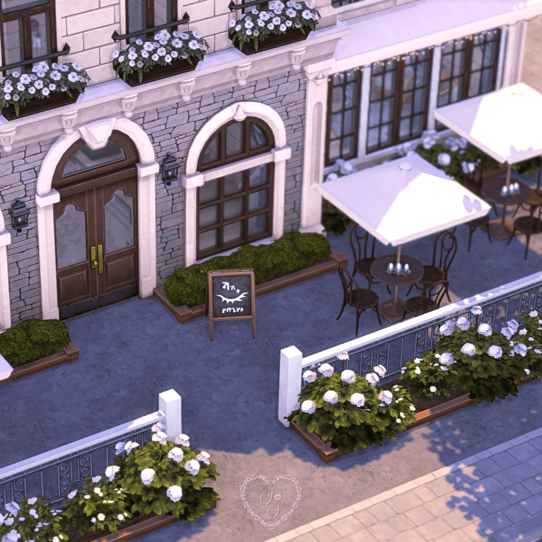 Outdoor dining space with white umbrellas and a hand-written café menu sign near the flower beds.