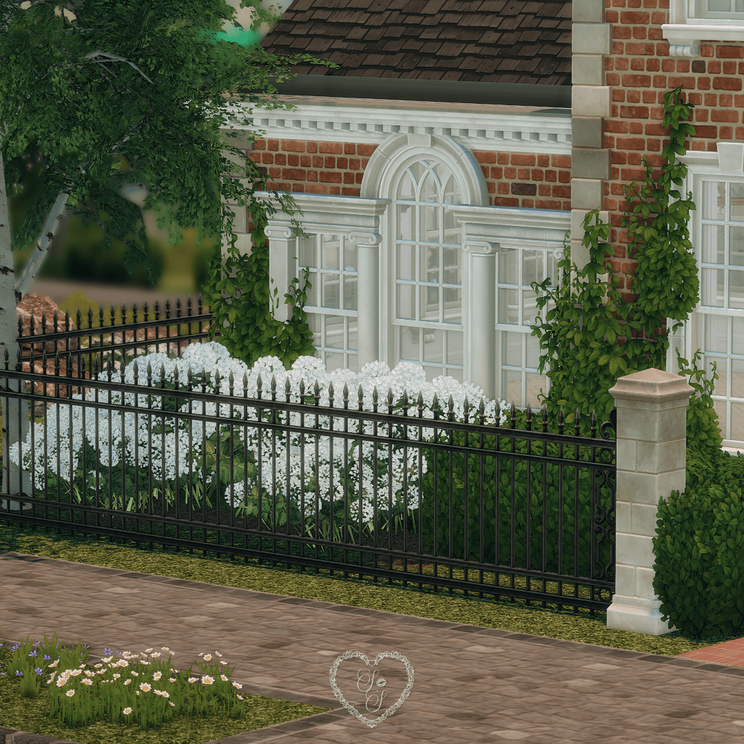 Detail of the Classic Colonial’s front garden with arched windows, white florals, climbing ivy, and iron fencing, elegant landscaping in The Sims 4.